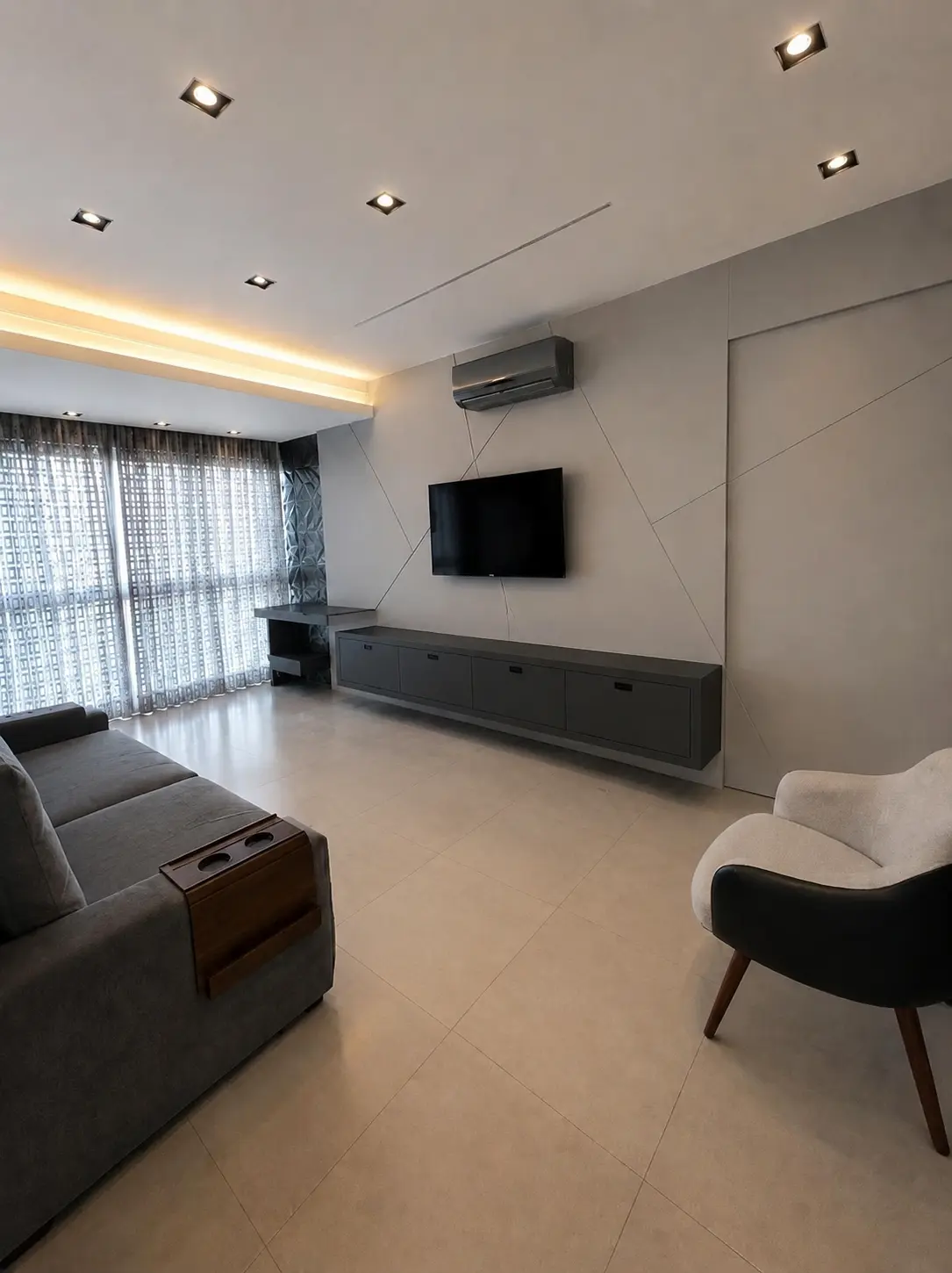 Sala de estar mobiliada com painel de televisão e iluminação embutida